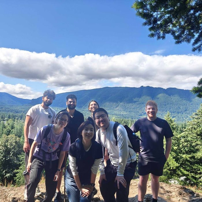 Lab members on a hike with mountains behind them